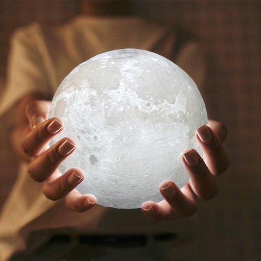 3D moon lamp held in hands glowing